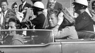 President John F. Kennedy waves from his car in a motorcade approximately one minute before he was shot in Dallas. Pic: AP