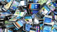 Mobile phones background. Pile of different modern smartphones. 3d