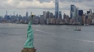 The Statue of Liberty is seen in front of the Manhattan Skyline in New York City