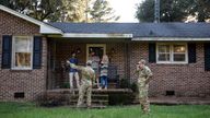 Airmen from Joint Base Charleston speak to a family living right next to the site of a crashed F-35 about the operation to recover the fighter jet and requests for the family in Williamsburg County, S.C., on Monday, Sept. 18, 2023. (Henry Taylor/The Post And Courier via AP)