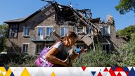 A woman carries a dog while walking past a house heavily damaged by recent shelling in the course of Russia-Ukraine conflict in Donetsk, Russian-controlled Ukraine, September 27, 2023. REUTERS/Alexander Ermochenko