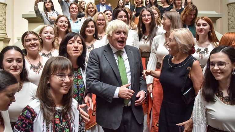 Former British Prime Minister Boris Johnson poses for a picture with students after the awarding of the honorary title 