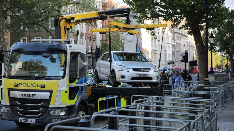 A police recovery truck lifts a car after it collided with the gates of Downing Street in London. The Metropolitan Police said armed officers have arrested a man on suspicion of criminal damage and dangerous driving. Picture date: Thursday May 25, 2023.

