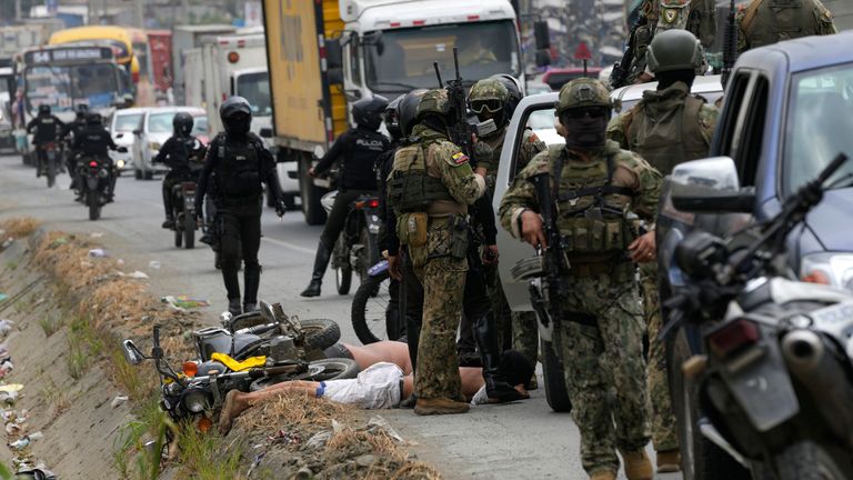 Police officers and soldiers detain two men outside of the Zone 8 Deprivation of Liberty Center who were supporting inmates protesting for the return of Los Choneros leader Adolfo Mac..as, alias "Fito," in Guayaquil, Ecuador, Monday, Aug. 14, 2023. Authorities moved the leader of one of Ecuador&#39;s most powerful gangs into a maximum-security prison Saturday, three days after the assassination of a presidential candidate who had denounced threats from the feared criminal. (AP Photo/Martin Mejia)