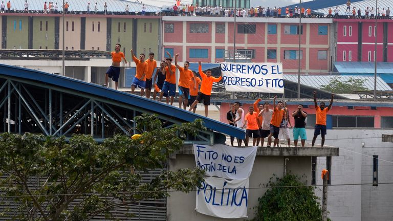 Inmates shout from the rooftop of the Zone 8 Deprivation of Liberty Center to demand the return of Los Choneros leader Adolfo Mac..as, alias ...Fito,... in Guayaquil, Ecuador, Monday, Aug. 14, 2023. Authorities moved the leader of one of Ecuador...s most powerful gangs into a maximum-security prison Saturday, three days after the assassination of a presidential candidate who had denounced threats from the feared criminal. (AP Photo/Martin Mejia)