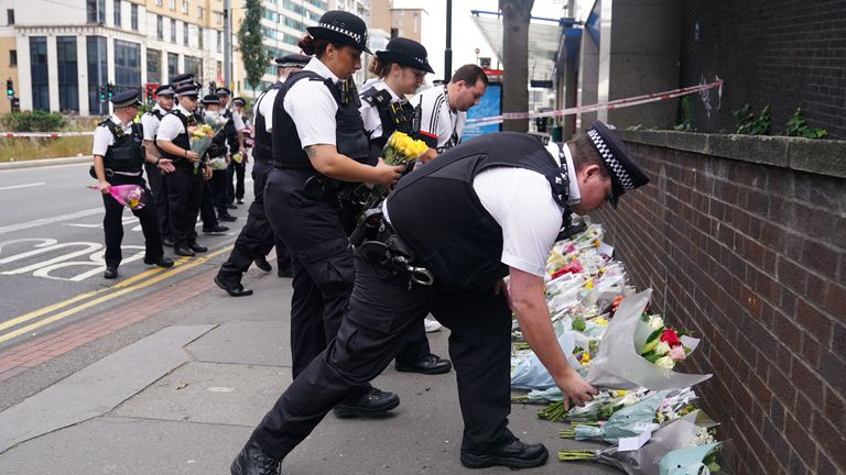 Police officers lay flowers at the scene in Croydon where 15-year-old Elianne Andam was stabbed to death 