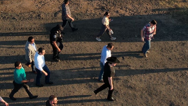 Elon Musk, Chief Executive Officer of SpaceX and Tesla and owner of X, walks past migrants detained by the U.S. Border Patrol during a visit to the U.S. border with Mexico in Eagle Pass, Texas, U.S., September 28, 2023. REUTERS/Brian Snyder
