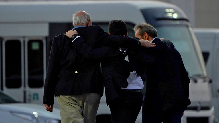 From left, Morad Tahbaz, Siamak Namazi, and Emad Sharghi walk away arm in arm from a Qatar Airways flight that brought them out of Tehran and to Doha, Qatar, Monday, Sept. 18, 2023. Five prisoners sought by the U.S. in a swap with Iran were freed Monday and headed home as part of a deal that saw nearly $6 billion in Iranian assets unfrozen. (AP Photo/Lujain Jo)