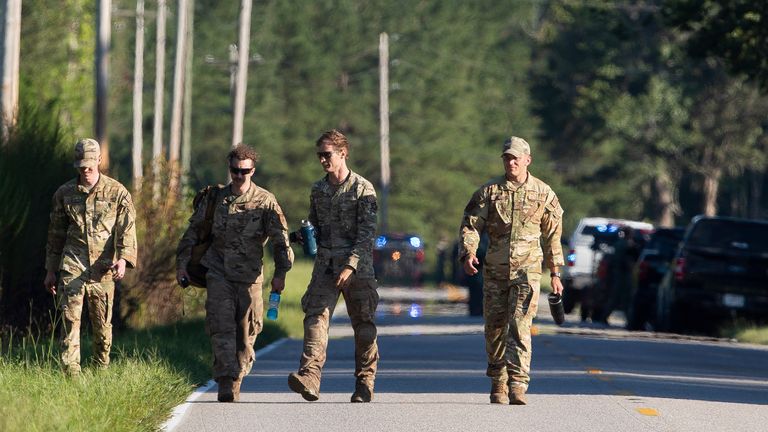 Airmen from Joint Base Charleston walk down Old Georgetown Road when setting up a base during the recovery process for an F-35 that crash landed in a field nearby in Williamsburg County, S.C., on Monday, Sept. 18, 2023. (Henry Taylor/The Post And Courier via AP)