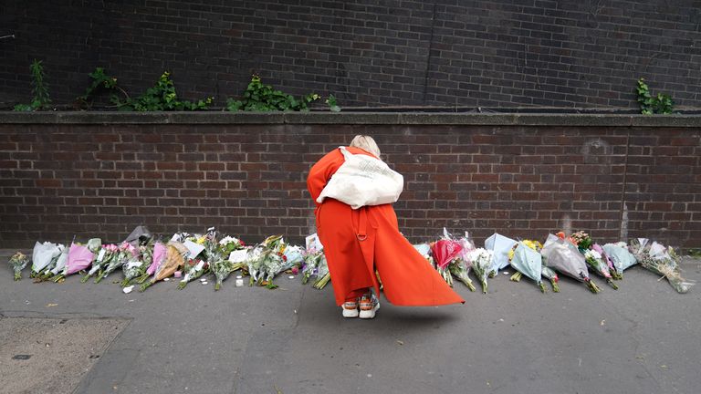 A woman lays flowers near the scene in Croydon, south London, where a 15-year-old girl was stabbed to death on Wednesday morning. Picture date: Thursday September 28, 2023.