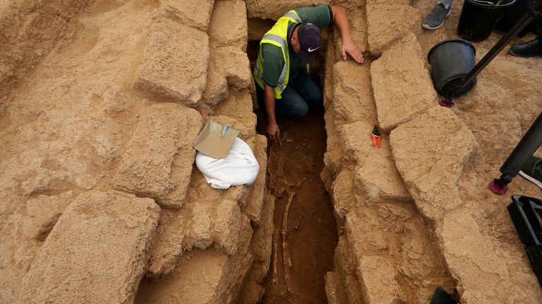 A Palestinian archaeologist removes the sand from a skeleton in a grave at the Roman cemetery in Jebaliya northern Gaza Strip, Saturday, Sept. 23, 2023. The ancient cemetery was uncovered last year during construction of a housing project. Researchers have uncovered 135 graves, including two sarcophagi made of lead. (AP Photo/Adel Hana)