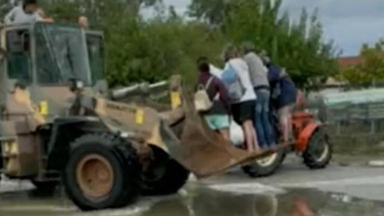 People evacuated in a bulldozer amid floods in Greece