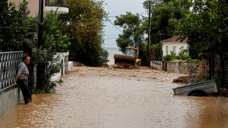 A woman stands in floodwater by her house after torrential rains destroyed the infrastructure and caused flooding in the area, in Agria, Pelion, central Greece September 6, 2023. REUTERS/Louisa Gouliamaki