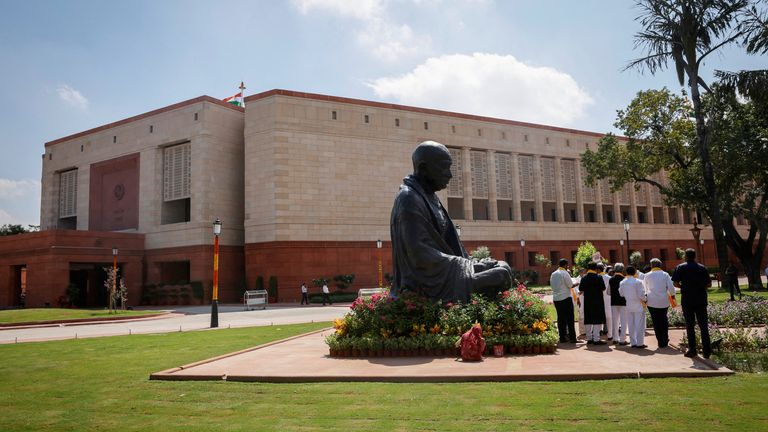 A statue of Mahatma Gandhi is pictured next to India&#39;s new parliament building a day before the inauguration of the building in New Delhi, India, September 18, 2023. REUTERS/Adnan Abidi