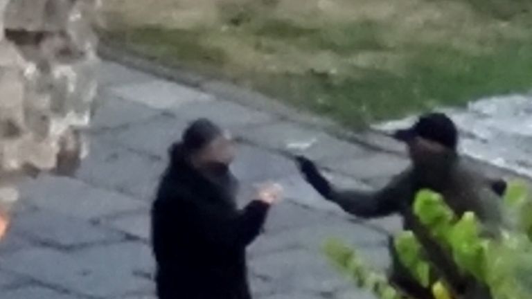 An armed man talks with a priest inside a monastery at a place given as Banjska
