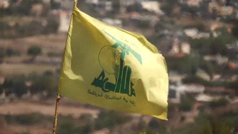 The yellow flag of Hezbollah is planted provocatively close to the border fence with Israel