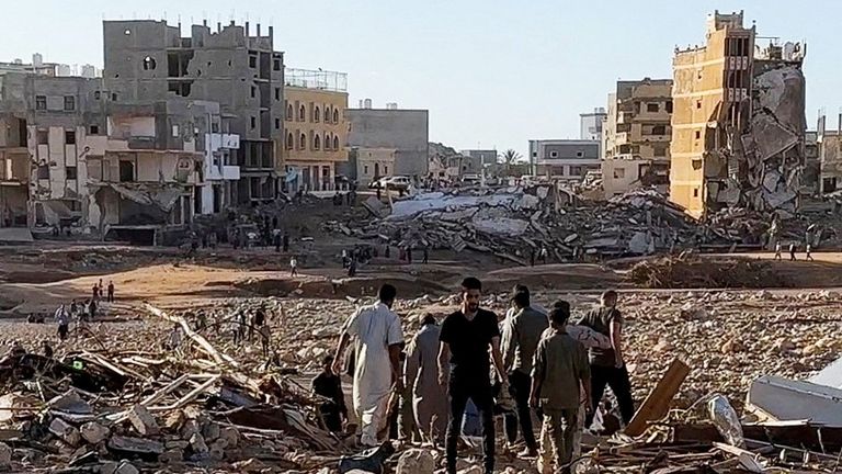 People walk through debris after a powerful storm and heavy rainfall hit Libya, in Derna
Pic:Ali M.Bomhadi/Reuters
