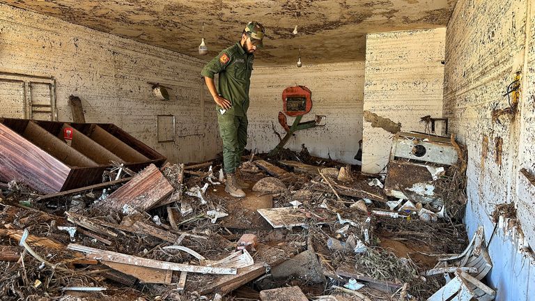 A Libyan soldier inspects a destroyed flat