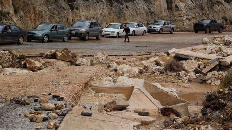 People on their cars are stuck at a damaged road as a powerful storm and heavy rainfall flooded hit Shahhat city, Libya