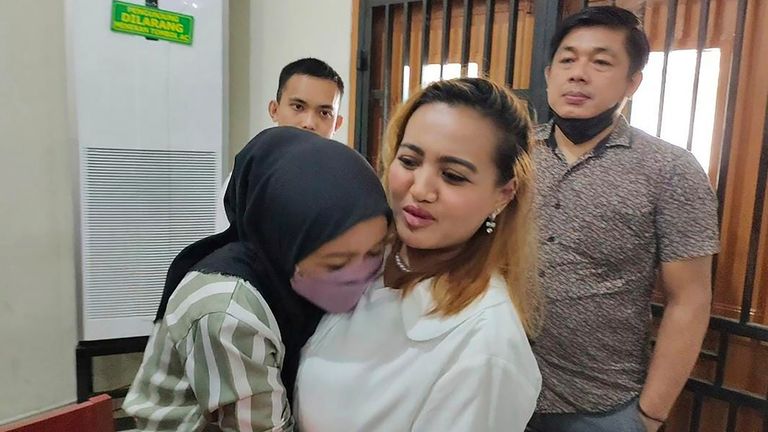 An unidentified relative hugs Lina Lutfiawati, center, after her trial in Palembang, South Sumatra, Indonesia, Tuesday, Sept. 19, 2023. The court sentenced her to two years in prison por saying a Muslim prayer and then eating pork on a TikTok video. (AP Photo/Mohammad Fadli)