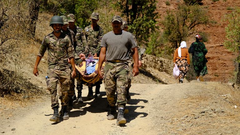 Soldiers carry an injured woman on a stretcher