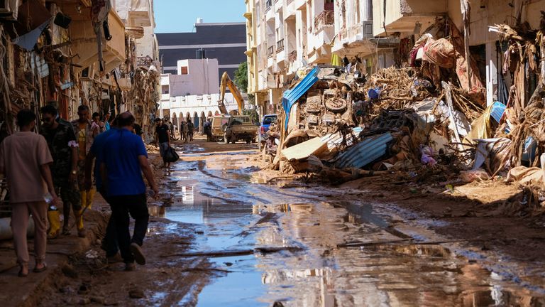 People walk in the mud between the rubbles, after a powerful storm and heavy rainfall hit Libya, in Derna, Libya September 13, 2023. REUTERS/Esam Omran Al-Fetori
