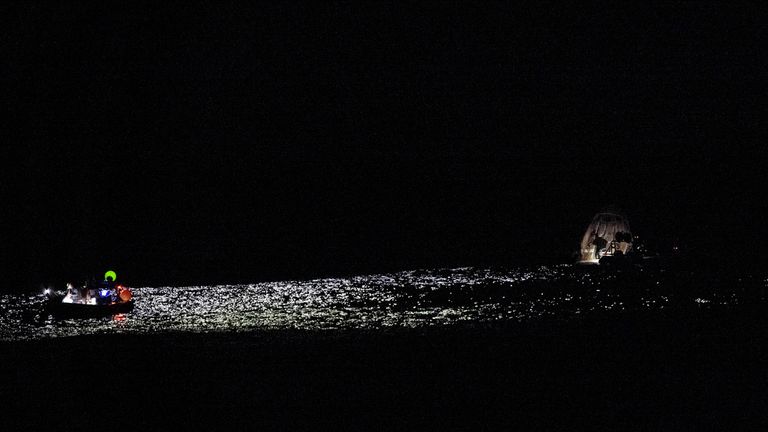 NASA support teams work around the SpaceX capsule shortly after its landing. Pic: AP