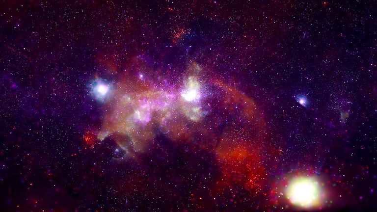 The Galactic Center is about 26,000 light-years from Earth, but telescopes like NASA’s Chandra X-ray Observatory (orange, green, blue, purple) allow us to visit virtually