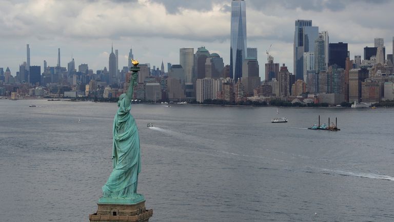 The Statue of Liberty is seen in front of the Manhattan Skyline in New York City