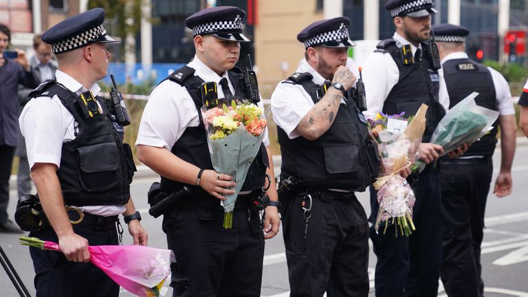 Police officers lay flowers at the scene in Croydon where 15-year-old Elianne Andam was stabbed to death