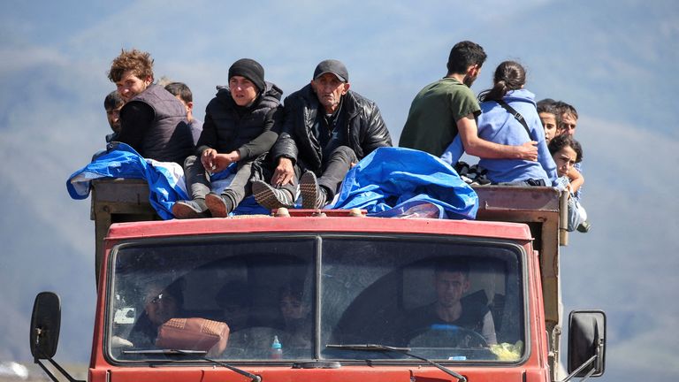 Refugees from Nagorno-Karabakh region ride in a truck upon their arrival at the border village of Kornidzor, Armenia