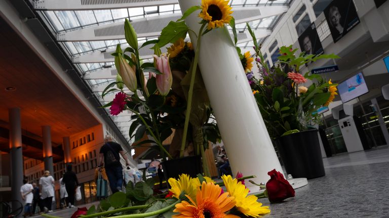 Medical personnel of the Erasmus Medical Centrum passes flowers who were left to commemorate victims of a shooting in Rotterdam, Netherlands, Friday, Sept. 29, 2023. Police in the Netherlands said a lone gunman wearing a bulletproof vest opened fire in an apartment and a hospital in the Dutch port city of Rotterdam, Thursday, Sept. 28, 2023, killing three people, including a 14-year-old girl. (AP Photo/Peter Dejong)
