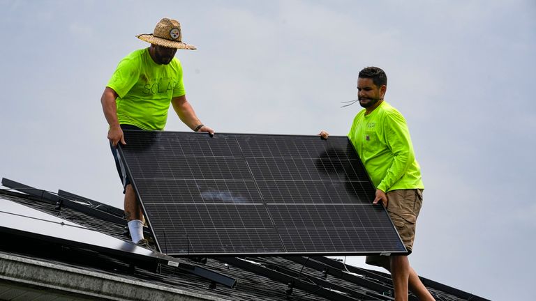 FILE - Even Berrios, left, and Nicholas Hartnett, owner of Pure Power Solar, install a solar panel on the roof of a home in Frankfort, Ky., July 17, 2023. Pic: AP