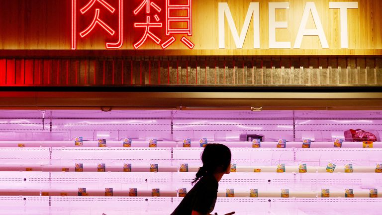 A customer walks past nearly empty shelves at a supermarket as super typhoon Saola approaches, in Hong Kong, China, August 31, 2023. REUTERS/Tyrone Siu
