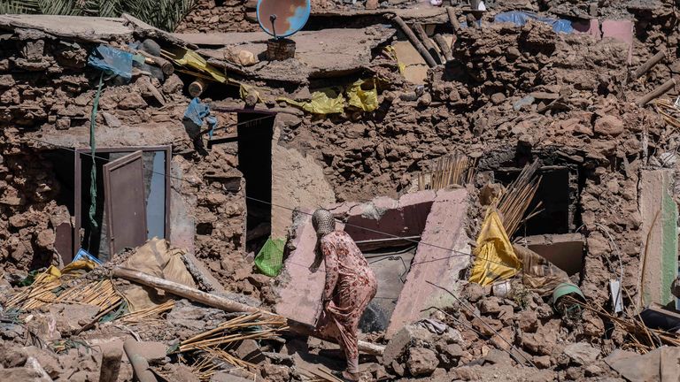 A woman tries to recover some of her possessions from her home which was damaged by the earthquake in the village of Tafeghaghte, near Marrakech, Morocco, Monday, Sept. 11, 2023. Rescue crews expanded their efforts on Monday as the earthquake&#39;s death toll continued to climb to more than 2,400 and displaced people worried about where to find shelter. (AP Photo/Mosa&#39;ab Elshamy)