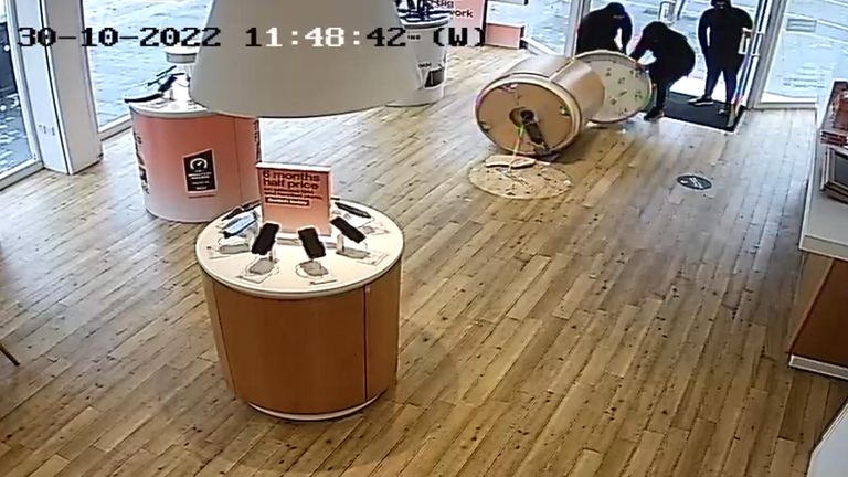 CCTV footage shows a gang of thieves stealing an entire stand pf phones from a Three UK store 