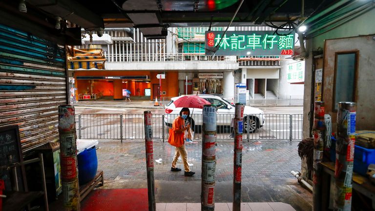 A woman holding an umbrella walks past a shuttered store at a food centre as super typhoon Saola approaches Hong Kong
Pic:AP
