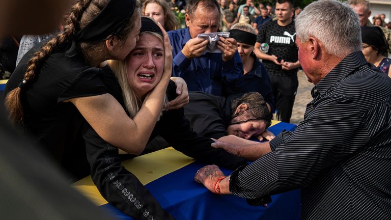 A woman cries on the coffin of Ivan Yaroviy, a Ukrainian helicopter navigator in Poltava. Pic: AP