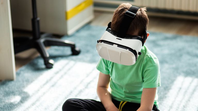 Little boy using virtual reality headset in his room. stock photo