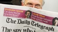 A passenger reads the Daily Telegraph newspaper 