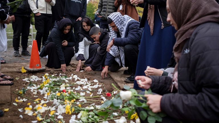 Mourners place flowers at the grave of Wadea Al-Fayoume