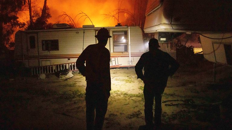 A firefighter and resident converse on how to protect his possessions as a wildfire called the Highland Fire burns in Aguanga, California
Pic:AP