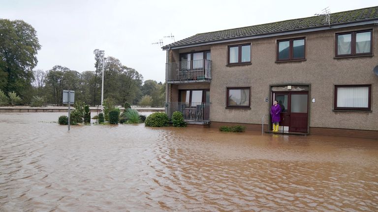 Rosie Galloway looks at flood water outside her property in Brechin, Scotland, as Storm Babet batters the country 
