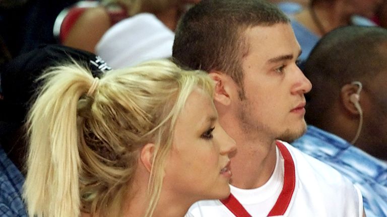 Singer Britney Spears (L) and her boyfriend, Justin Timberlake of "&#39;N Sync," watch from the sidelines during a celebrity basketball game at the pop band&#39;s "Challenge for the Children III" event at the Thomas & Mack Center in Las Vegas July 29, 2001.
