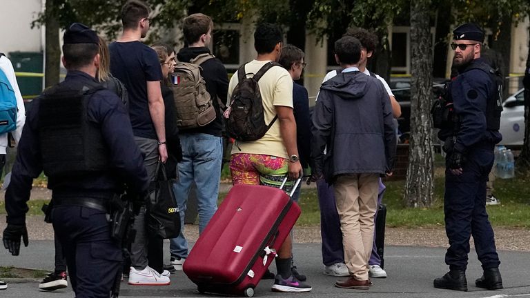 Schoolchildren leave the Gambetta high school after a man armed with a knife killed a teacher and wounded two others in Arras, northern France, Friday, Oct. 13, 2023. A man of Chechen origin who was under surveillance by the French security services over suspected radicalization stabbed a teacher to death at his former high school and critically wounded two other people in northern France. (AP Photo/Michel Euler)