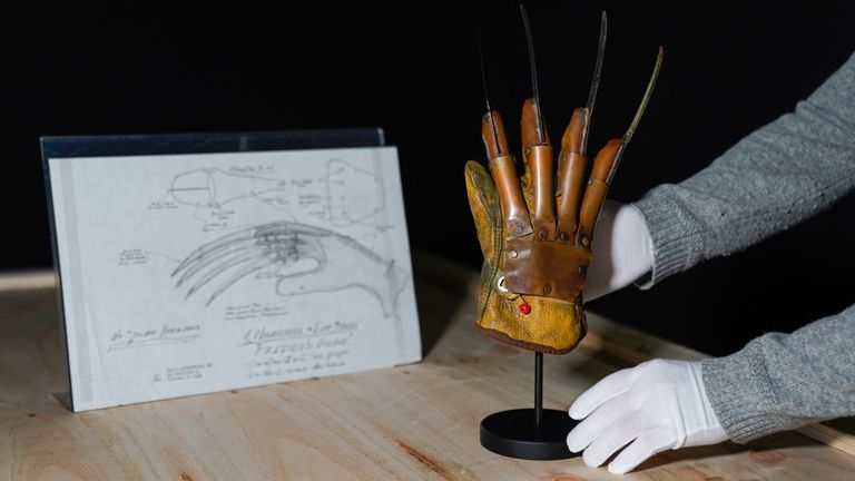 A Propstore employee places Freddy Krueger&#39;s (Robert Englund) screen matched metal glove armature (right) next to a hand drawn schematic (estimate £200,000 - 400,000) from the films &#39;A Nightmare on Elm street&#39; and &#39;A Nightmare on Elm Street 2: Freddy&#39;s Revenge&#39; respectively, during a preview for the showbiz memorabilia auction, at the Propstore in Rickmansworth, Hertfordshire. Picture date: Wednesday September 20, 2023.
