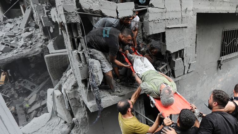 Palestinians carry an injured man out of the destruction following Israeli airstrikes on Gaza City. Pic; AP