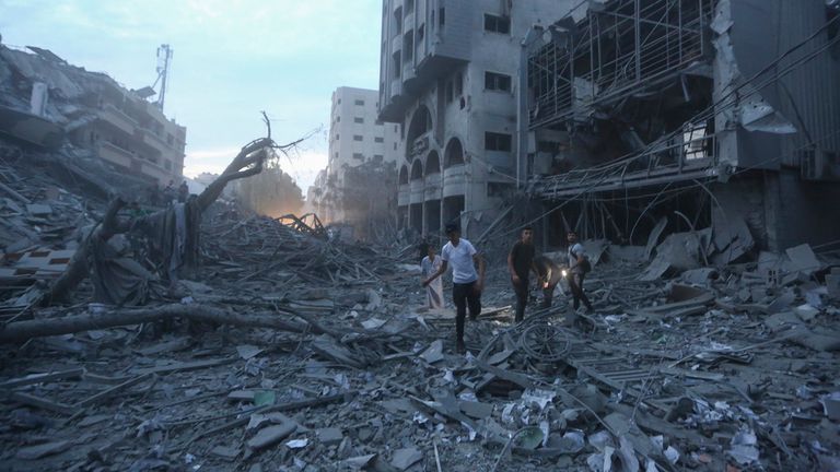 Palestinians inspect the ruins of a tower destroyed in an Israeli airstrike in Gaza City