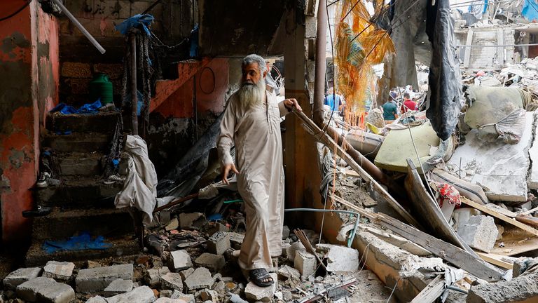 A Palestinian walks amid the rubble of a building destroyed in Israeli strikes, in Rafah in the southern Gaza Strip October 9, 2023. REUTERS/Ibraheem Abu Mustafa