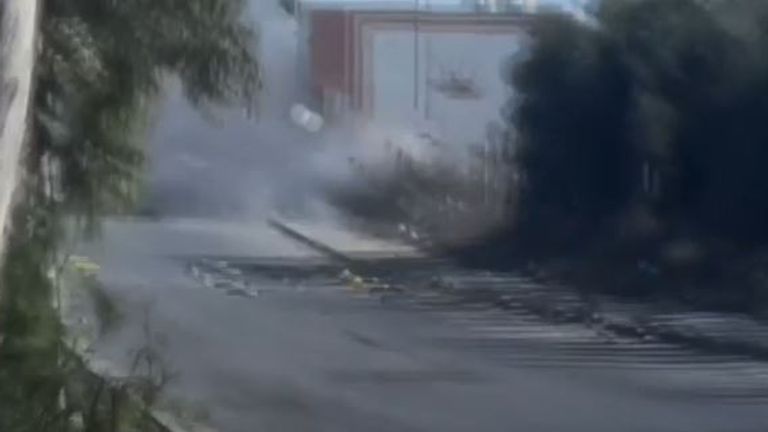 A grey cloud of smoke was seen in the road after the shell appeared to hit the car